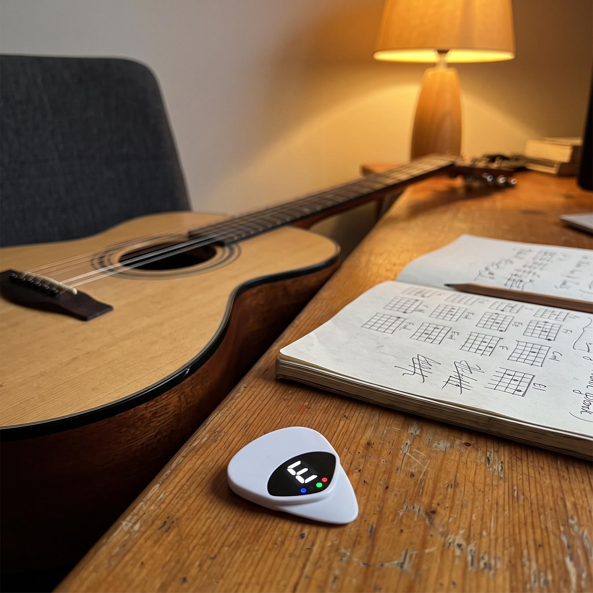 White Chordwell pick tuner on a songwriter’s desk