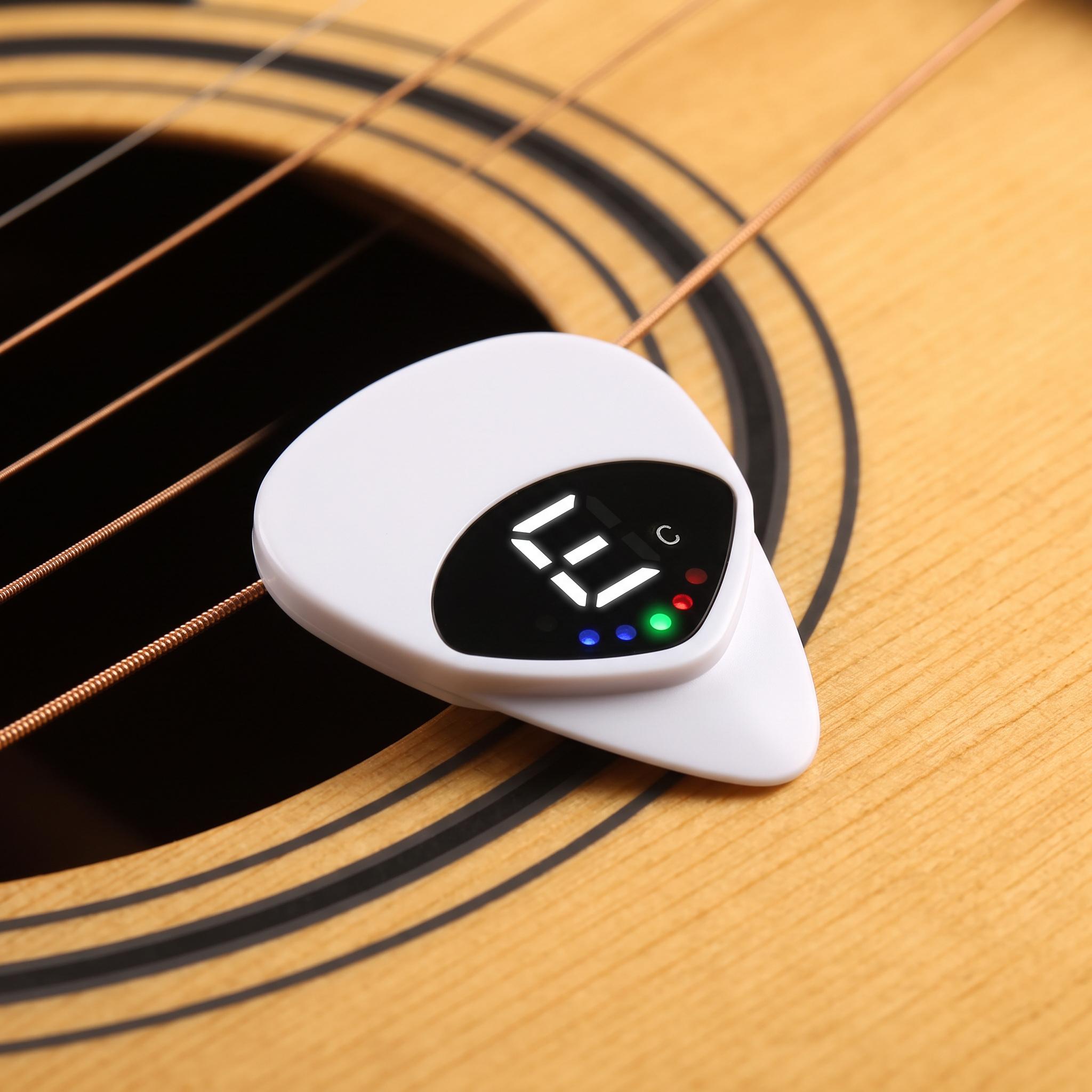 Chordwell white pick tuner beside an acoustic guitar