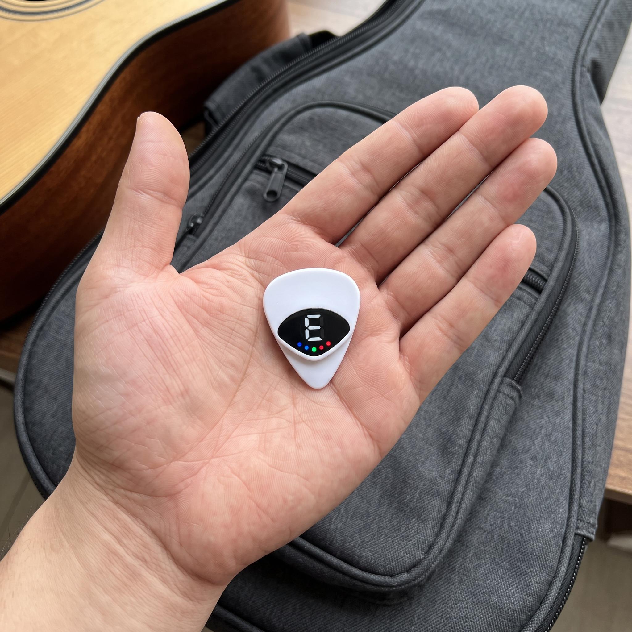 Compact white pick tuner ready to pack in a gig bag