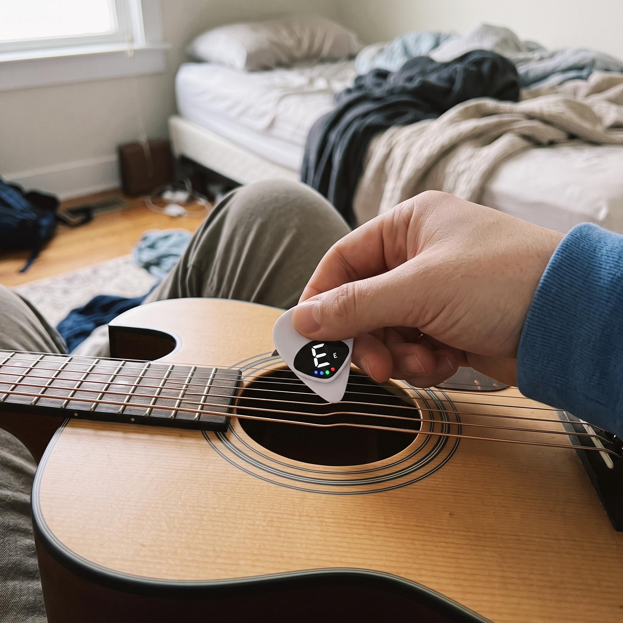 White Chordwell pick tuner beside an acoustic guitar