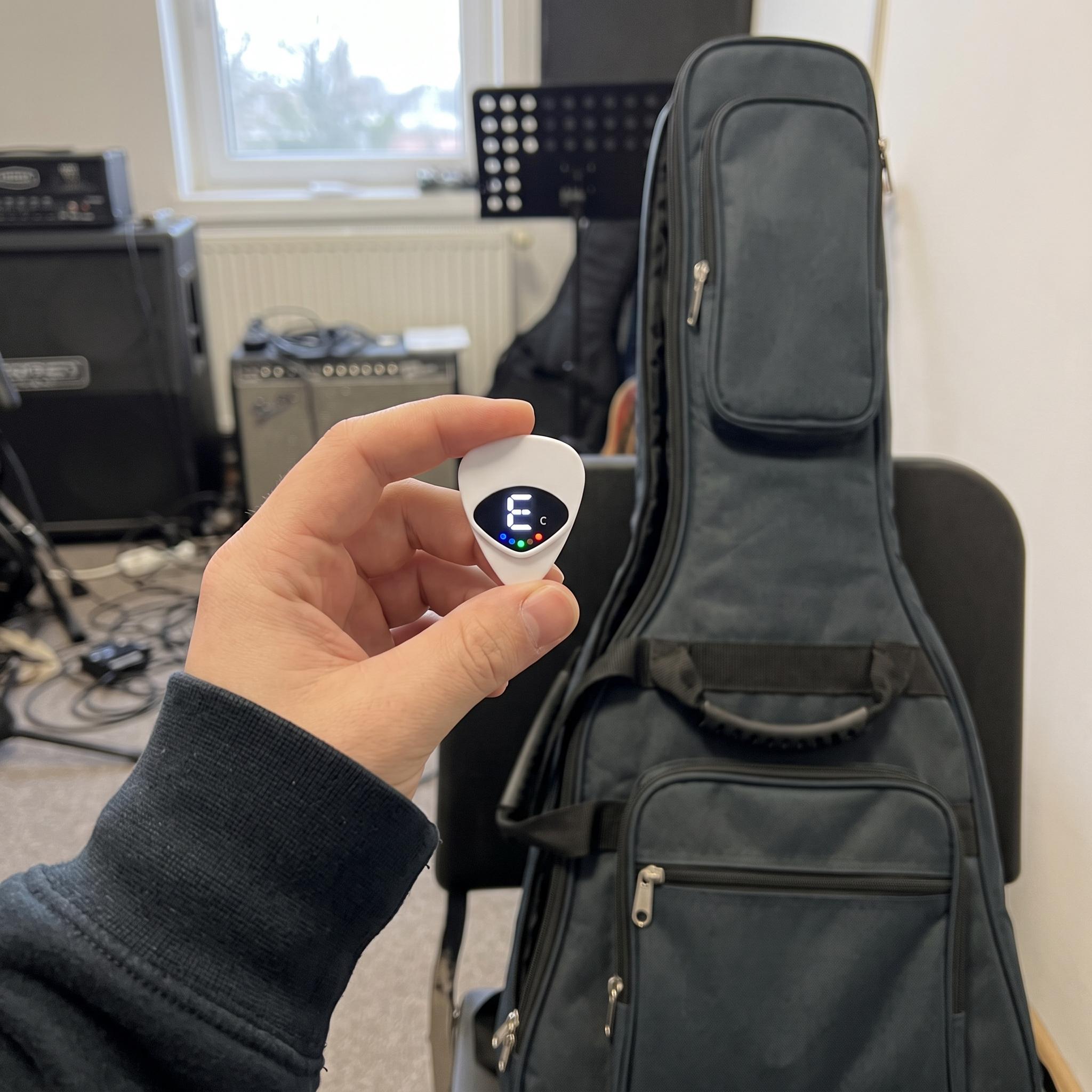 Player holding a white Chordwell pick tuner