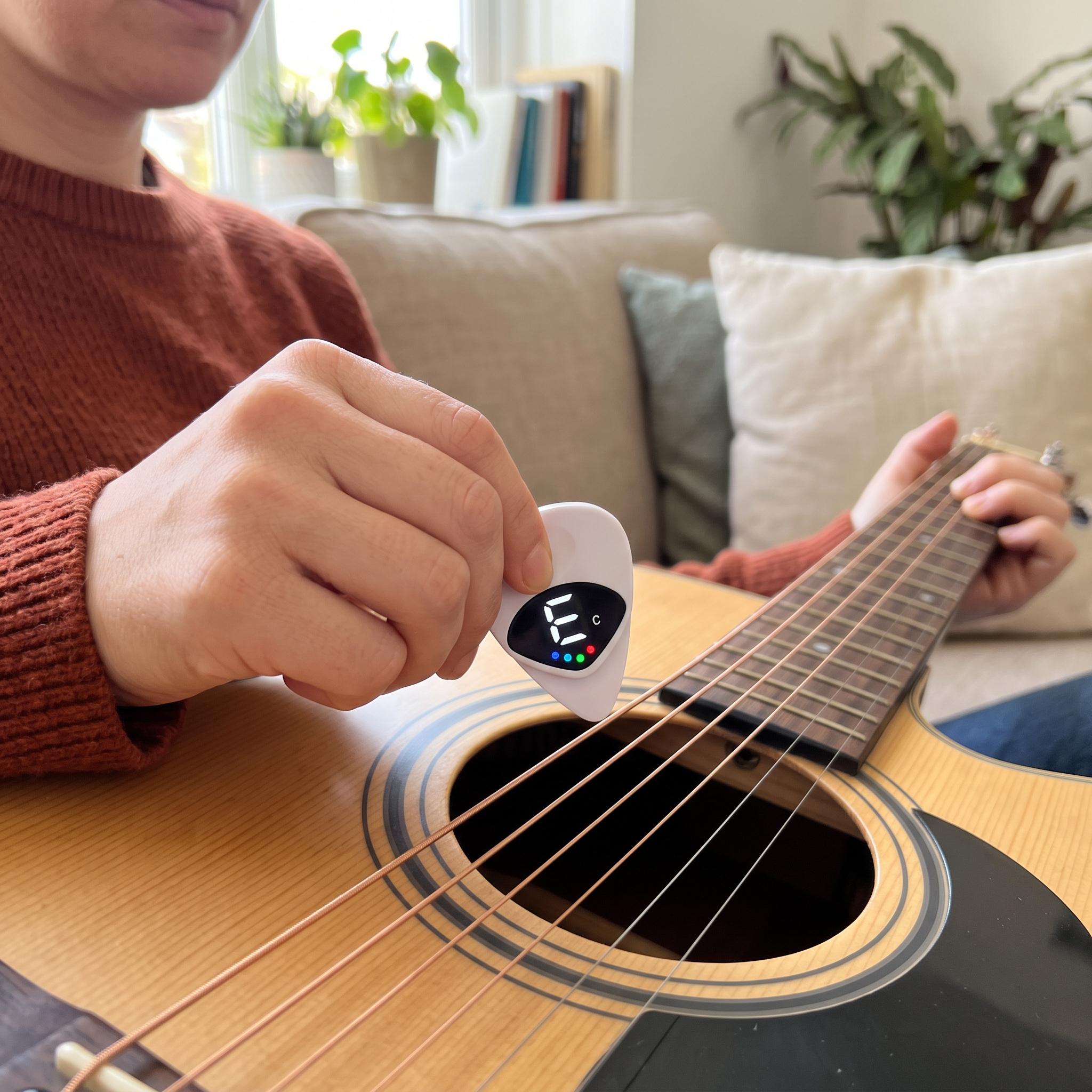 Woman in a rust sweater checking an acoustic guitar with Chordwell